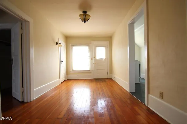 a view of a room with wooden floor and window