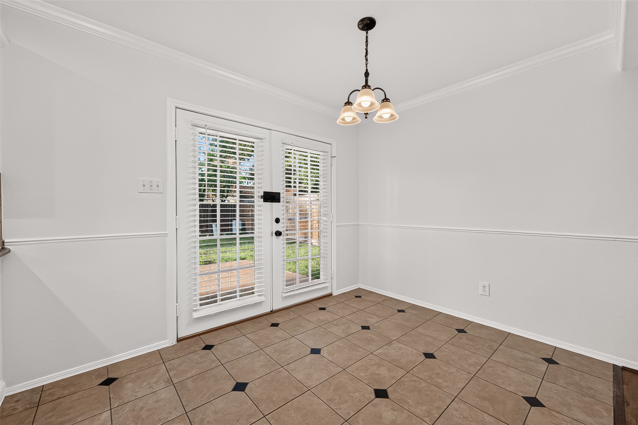 9322 Magnolia Ridge Drive Houston, TX 77070 - Photo 4 of 16 Dedicated dining area with tile flooring, classic chandelier, and French doors that step right out to the backyard