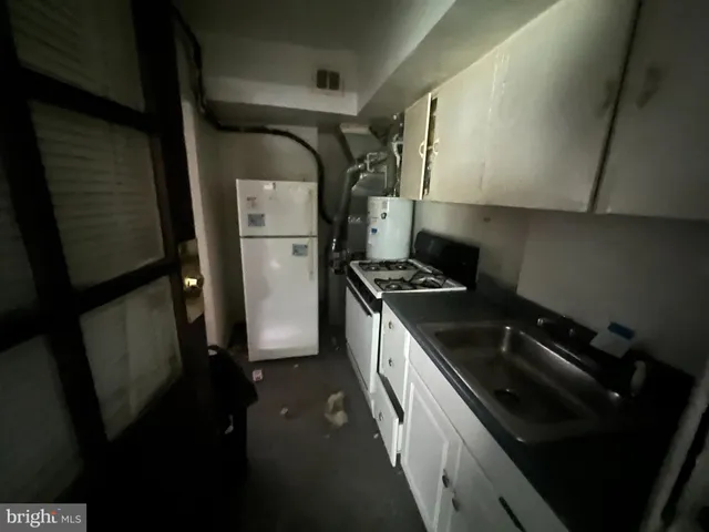 a kitchen with a sink a refrigerator and cabinets