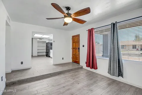 an empty room with closet and a ceiling fan