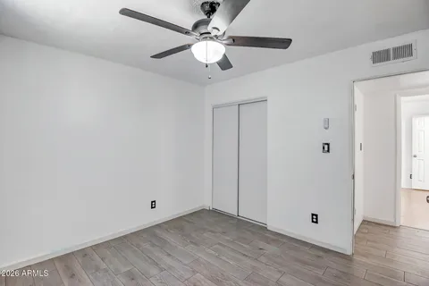 a view of an empty room with window and a ceiling fan