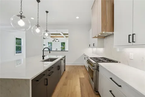 a kitchen with stove a sink and cabinets