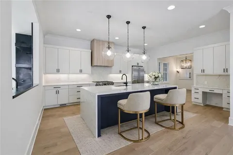 a kitchen with kitchen island a dining table chairs sink and cabinets