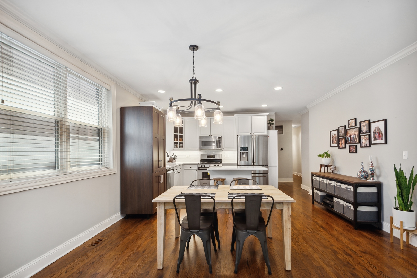 2147 West Rice Street, Unit 2E Chicago, IL 60622 - Photo 7 of 16 a kitchen with stainless steel appliances a dining table chairs stove refrigerator and cabinets