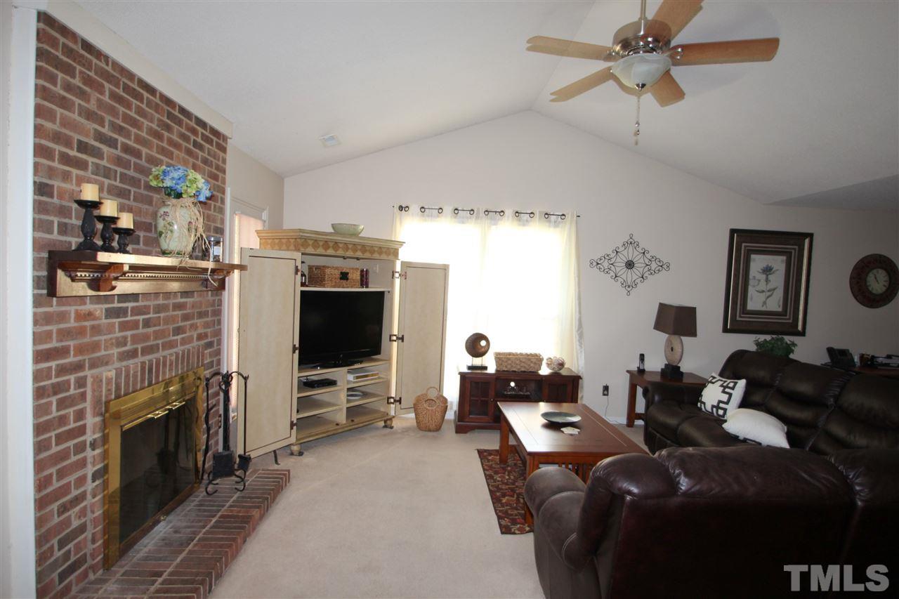 11833 North Exeter Way Raleigh, NC 27613 - Photo 2 of 16 a living room with furniture a fireplace and a flat screen tv