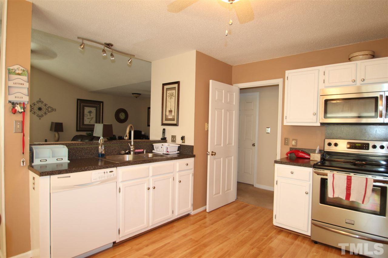 11833 North Exeter Way Raleigh, NC 27613 - Photo 5 of 16 a kitchen with stainless steel appliances granite countertop a sink and cabinets