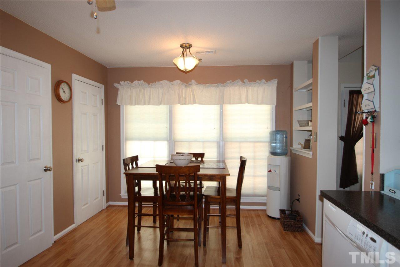 11833 North Exeter Way Raleigh, NC 27613 - Photo 6 of 16 a view of a dining room with furniture window and wooden floor