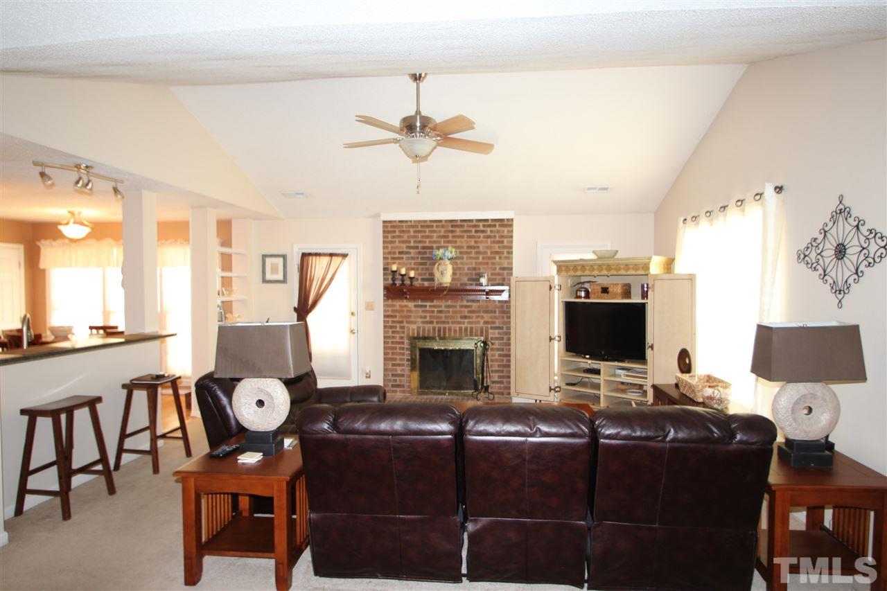 11833 North Exeter Way Raleigh, NC 27613 - Photo 7 of 16 a living room with furniture a fireplace and a flat screen tv