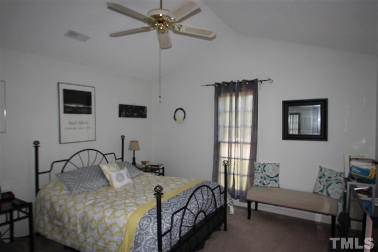 11833 North Exeter Way Raleigh, NC 27613 - Photo 9 of 16 a bedroom with a bed and a chandelier