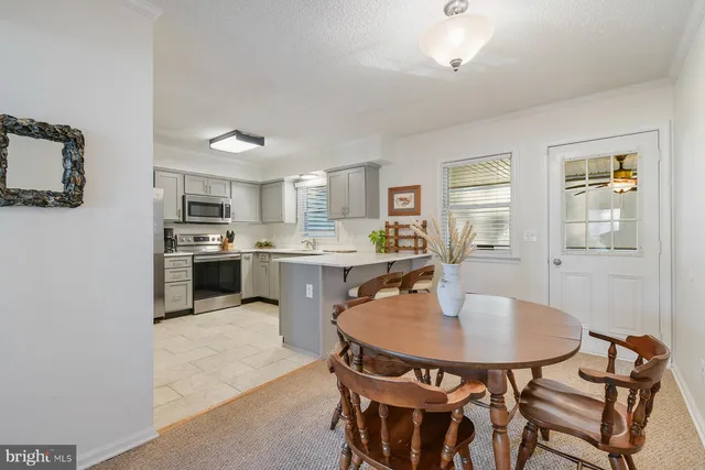 a kitchen with a dining table chairs and refrigerator