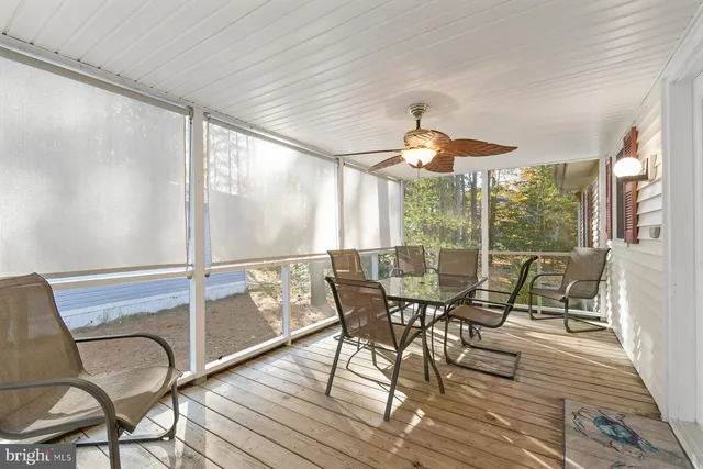 a dining room with wooden floor a chandelier a glass table and chairs
