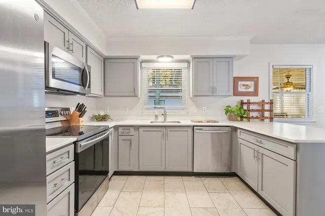 a kitchen with a sink stove top oven and cabinets
