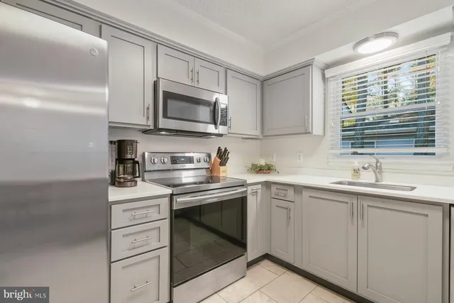 a kitchen with stainless steel appliances granite countertop a sink stove and microwave