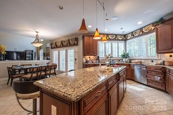 a kitchen with stainless steel appliances granite countertop a stove a sink a oven and a refrigerator