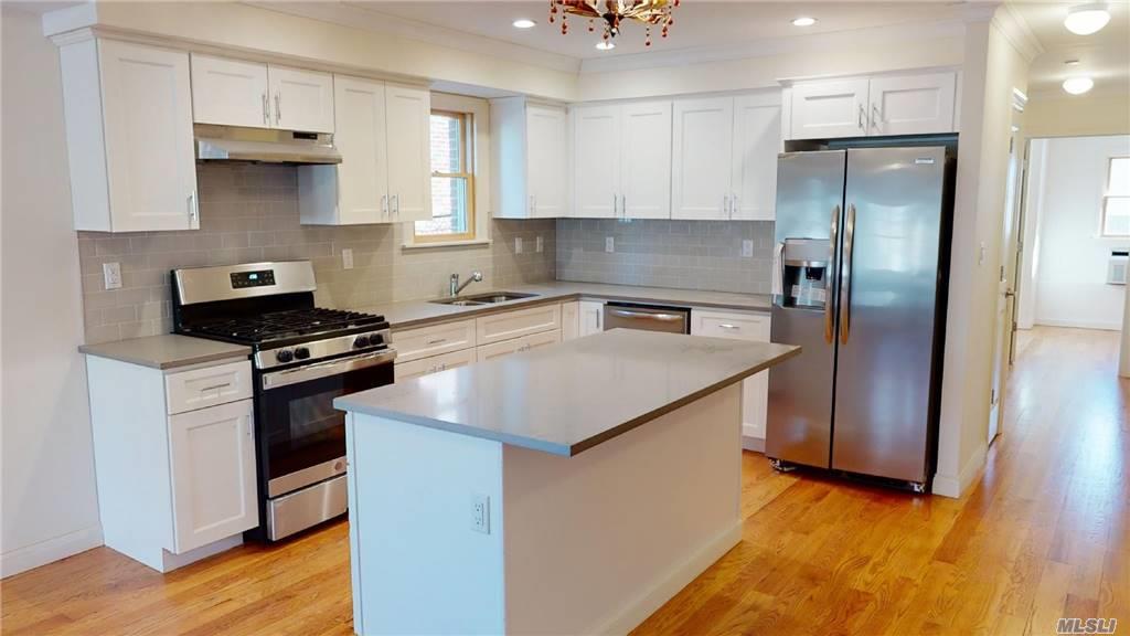 a kitchen with stainless steel appliances granite countertop a refrigerator a sink and a stove