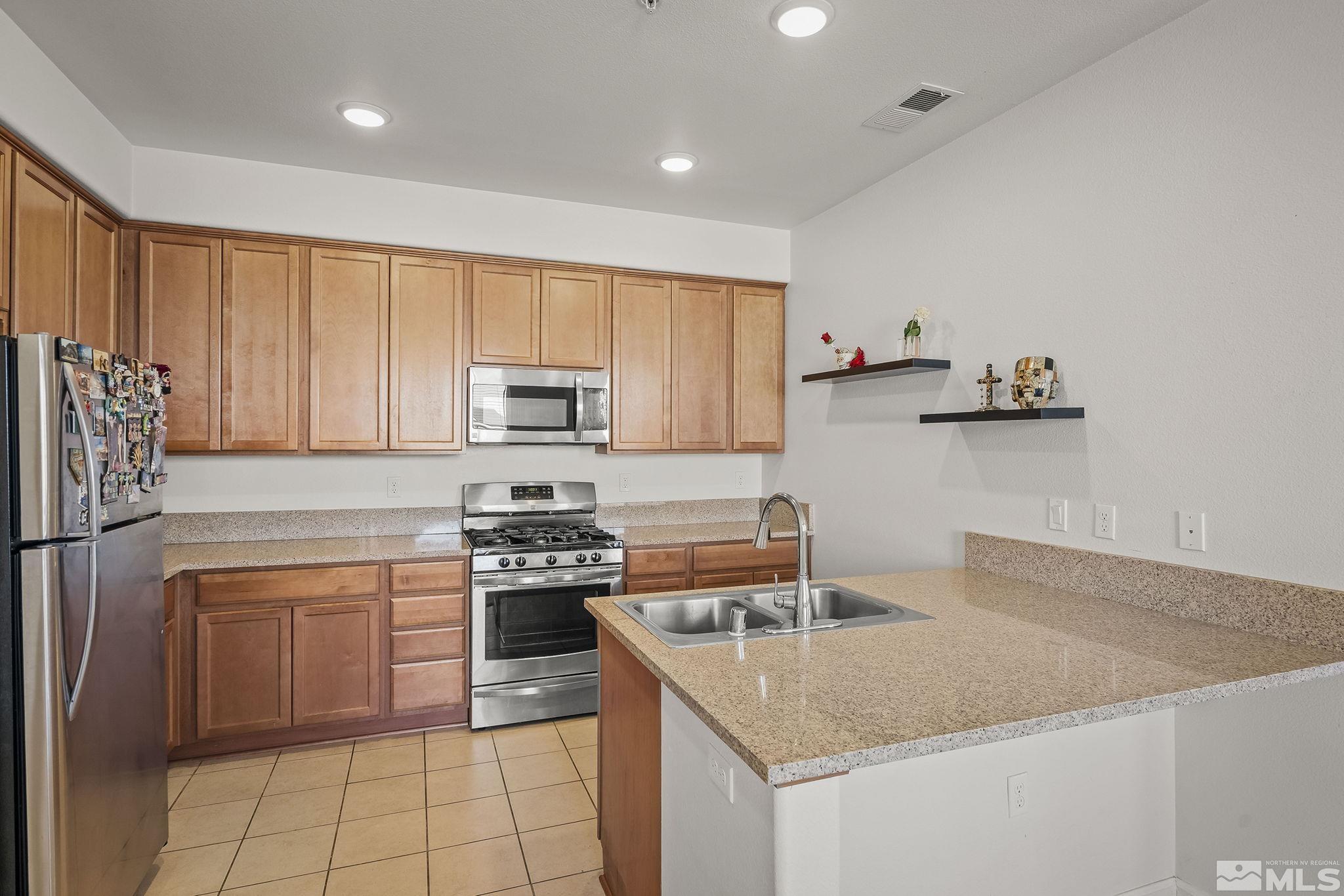 2490 Eastshore Place, Unit 401 Reno, NV 89509 - Photo 8 of 19 a kitchen with a stove a sink and a refrigerator