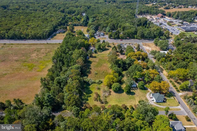 an aerial view of residential houses with outdoor space and trees all around