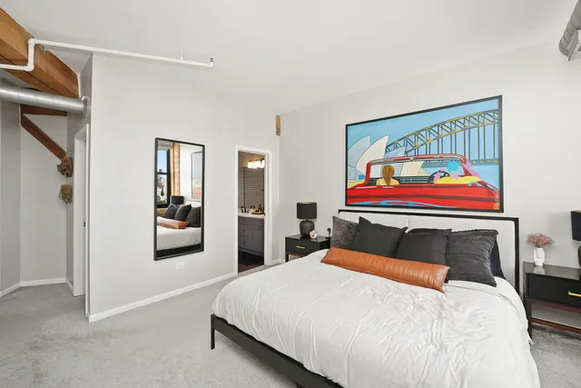 a bedroom with a bed and painting on the wall