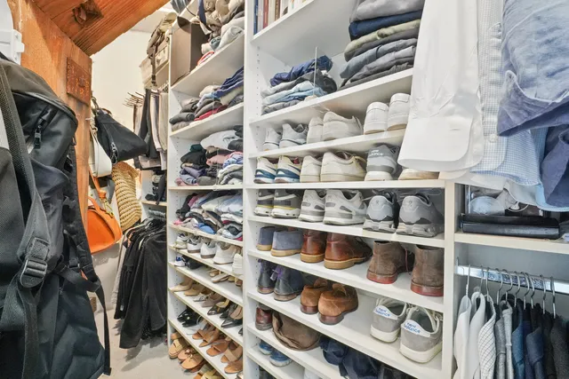a view of walk in closet with clothes and shoes