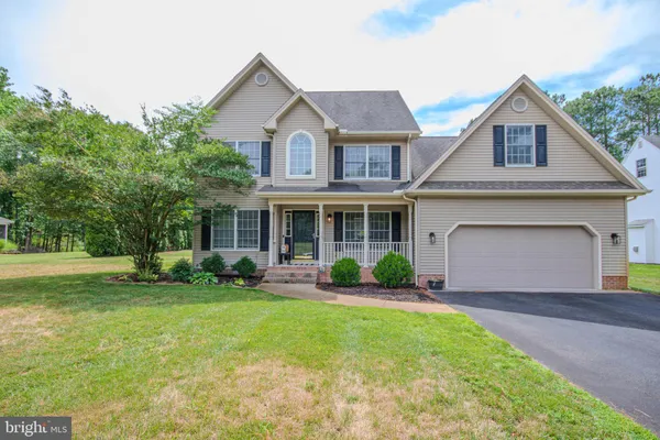 a front view of a house with yard and green space