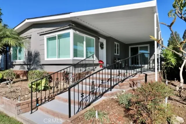 a view of house with a yard and potted plants