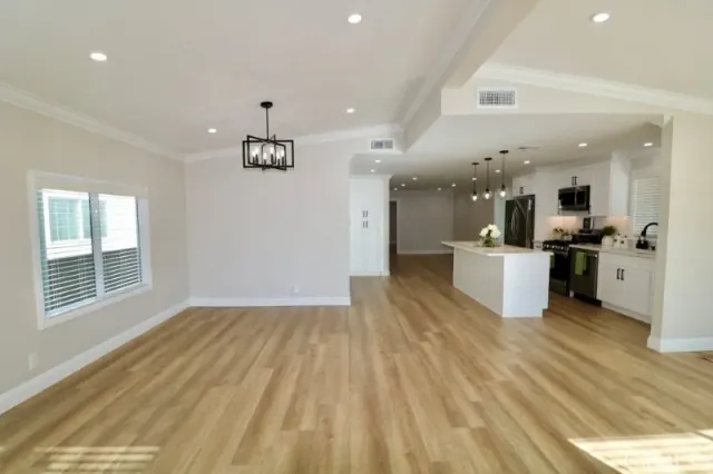 a kitchen with stainless steel appliances kitchen island granite countertop a sink a stove and refrigerator