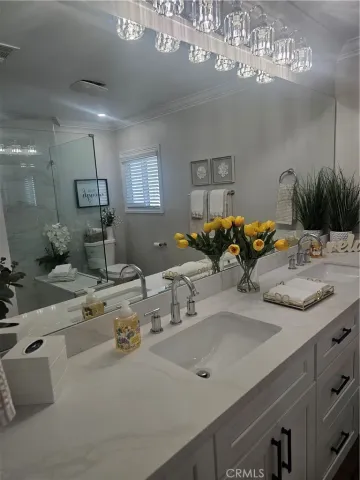a bathroom with a granite countertop sink a mirror and shower