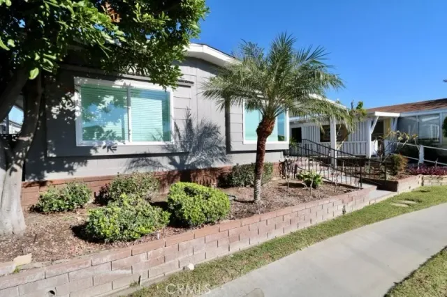 a front view of a house with garden and sitting area