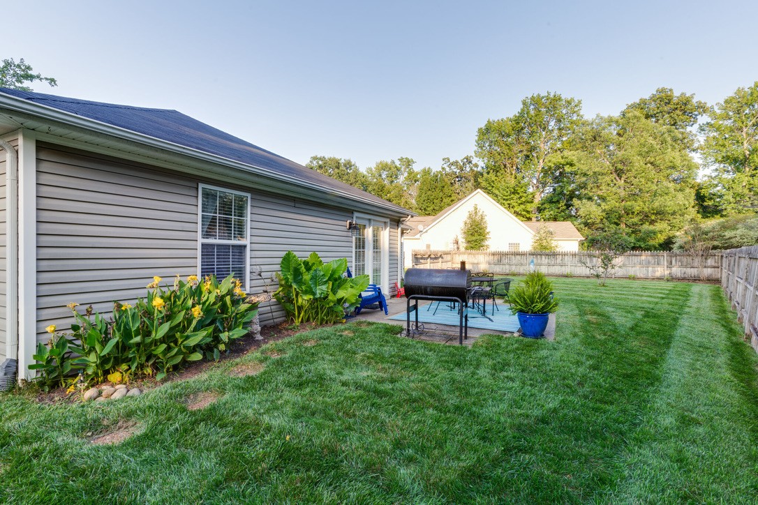 908 Chesire Court White House, TN 37188 - Photo 17 of 20 a backyard of a house with table and chairs plants and large tree