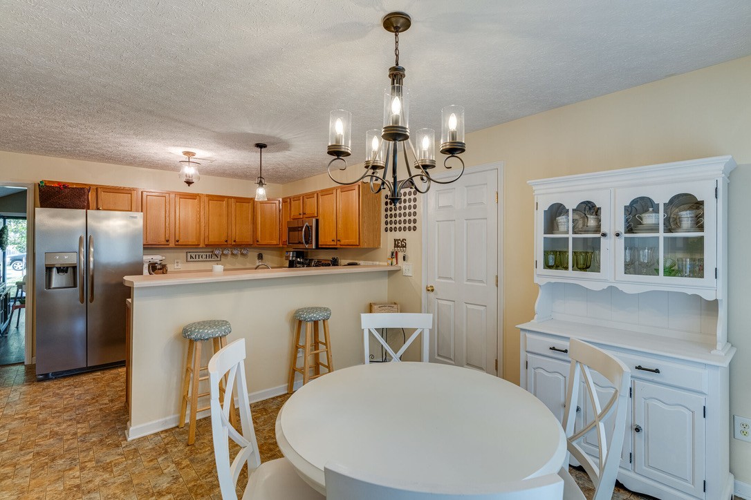 908 Chesire Court White House, TN 37188 - Photo 6 of 20 a kitchen with stainless steel appliances granite countertop a kitchen island a stove a table and chairs