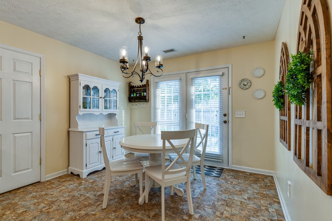 908 Chesire Court White House, TN 37188 - Photo 9 of 20 a dining room with furniture a chandelier and wooden floor