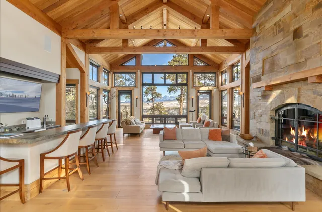 a living room with furniture and floor to ceiling windows