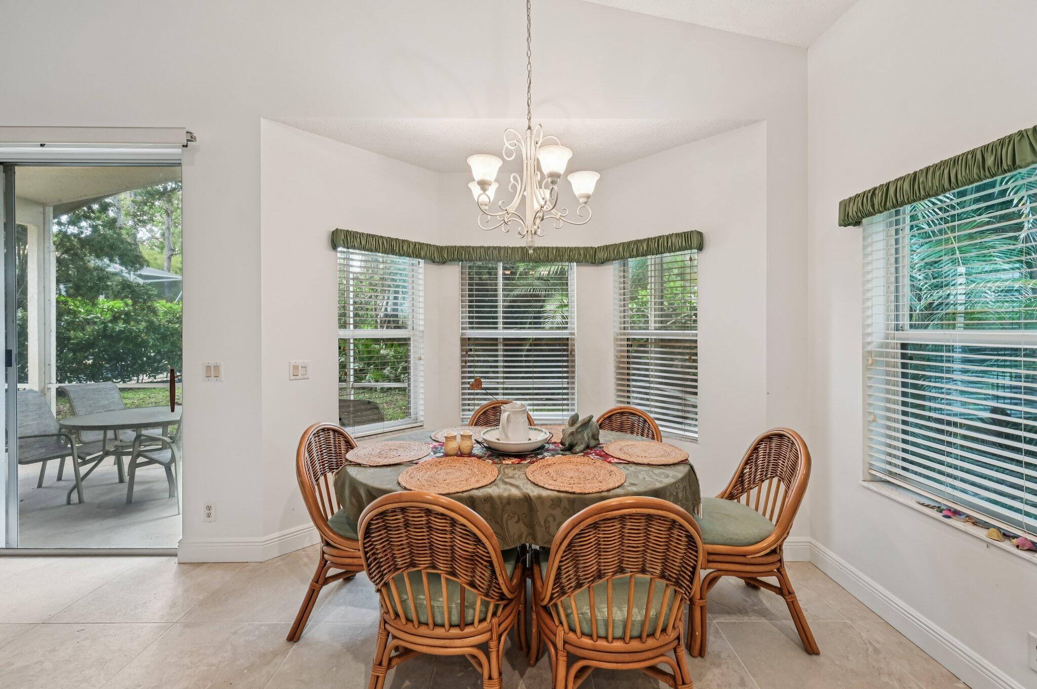 7184 Southeast Magellan Lane Stuart, FL 34997 - Photo 11 of 34 a dining room with furniture a chandelier and wooden floor