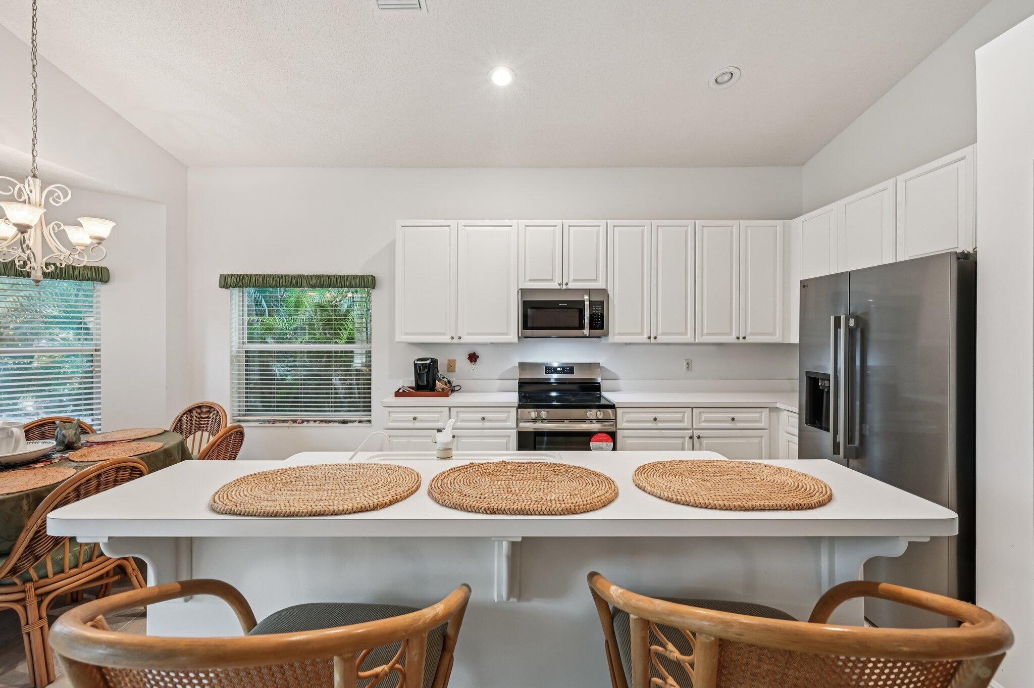 7184 Southeast Magellan Lane Stuart, FL 34997 - Photo 13 of 34 a kitchen with stainless steel appliances a dining table and chairs