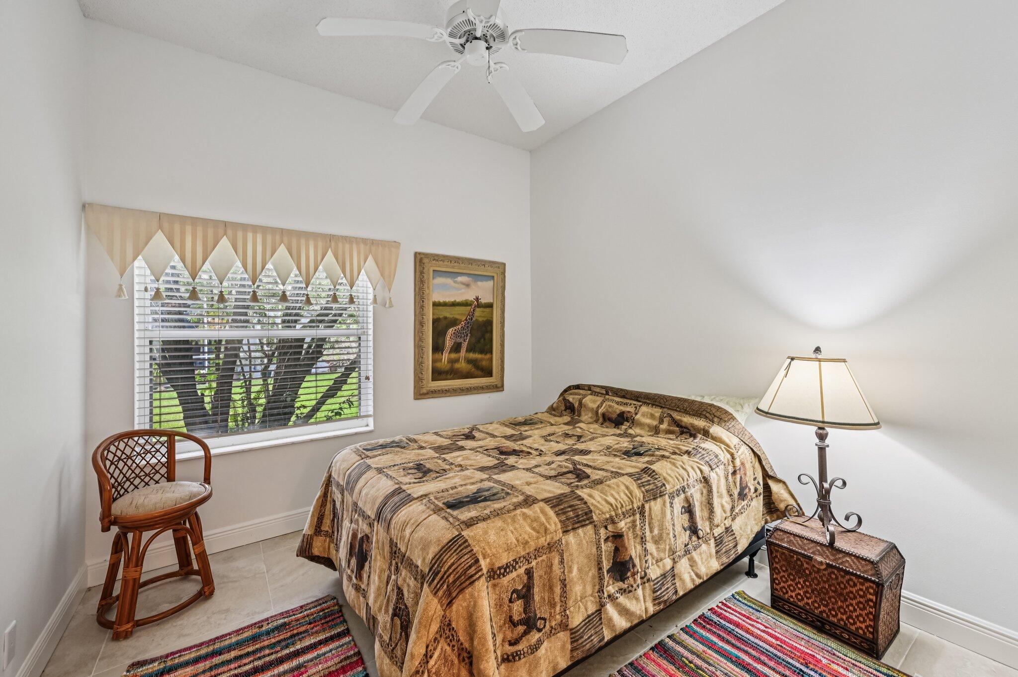 7184 Southeast Magellan Lane Stuart, FL 34997 - Photo 21 of 34 a bedroom with a bed a chair and a chandelier