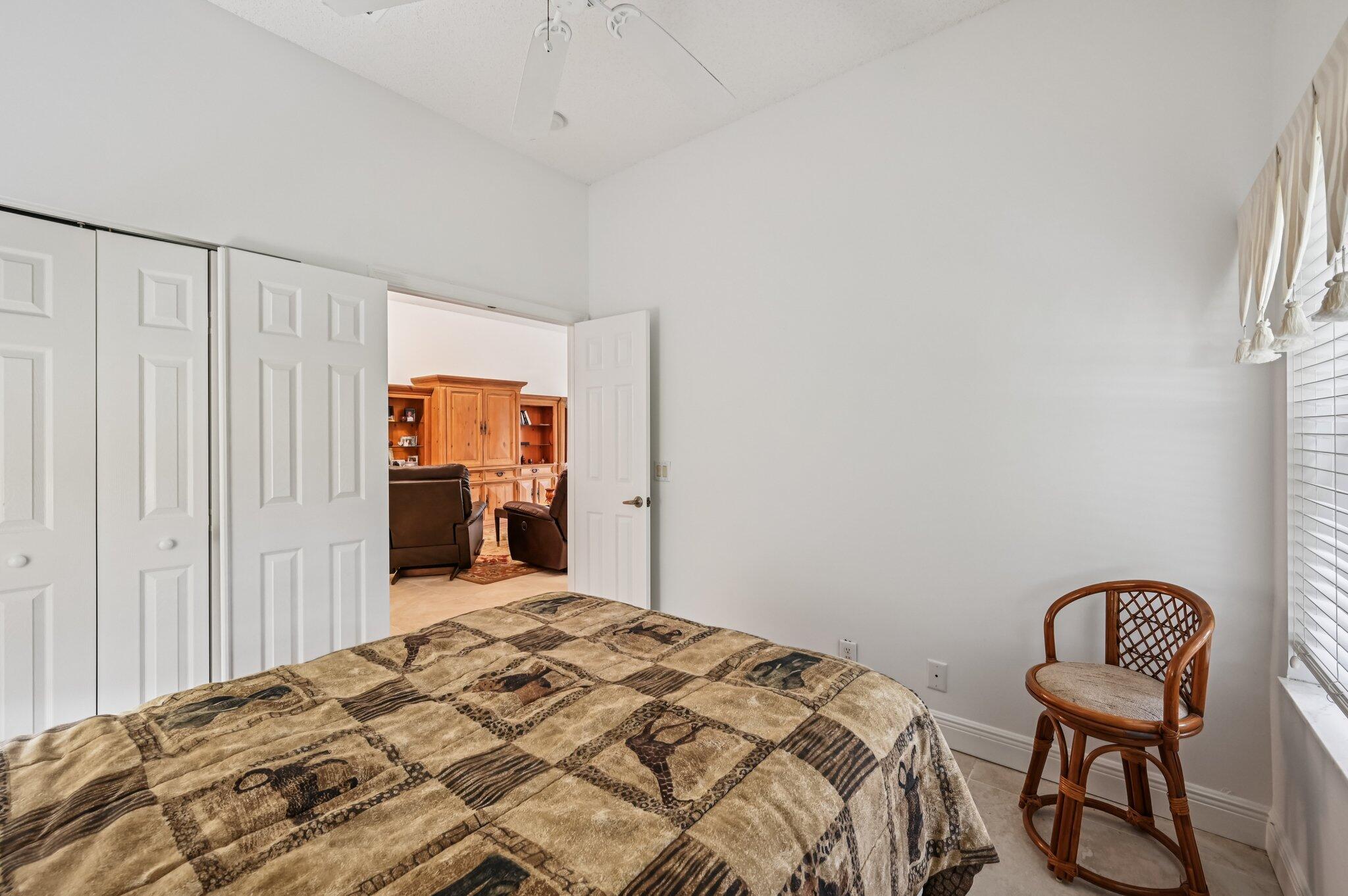 7184 Southeast Magellan Lane Stuart, FL 34997 - Photo 22 of 34 a bedroom with a bed and a chair