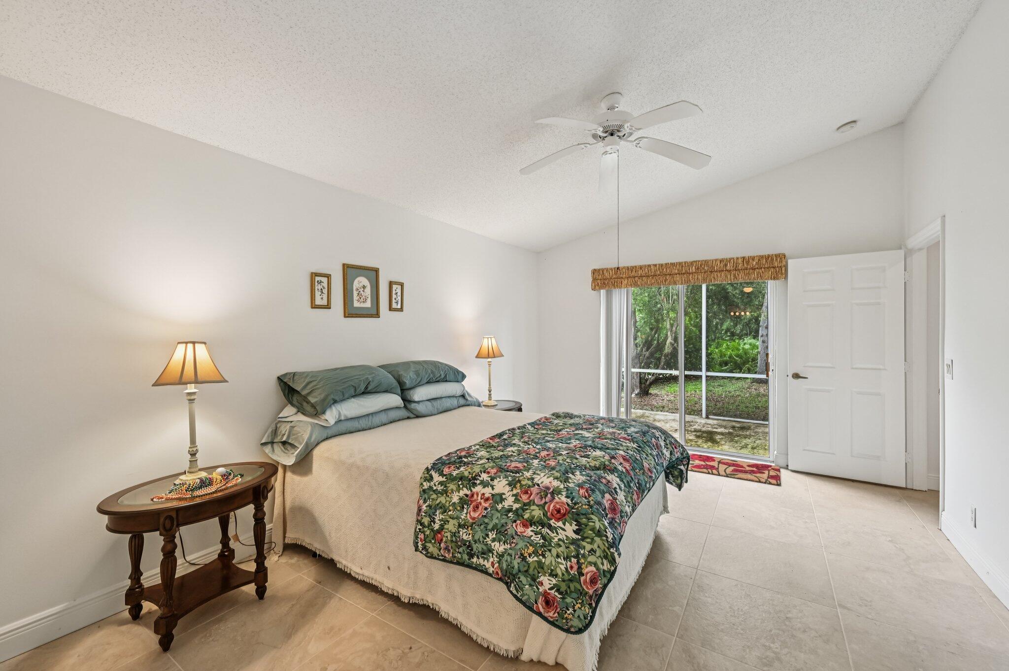7184 Southeast Magellan Lane Stuart, FL 34997 - Photo 24 of 34 a bedroom with a bed and a chandelier