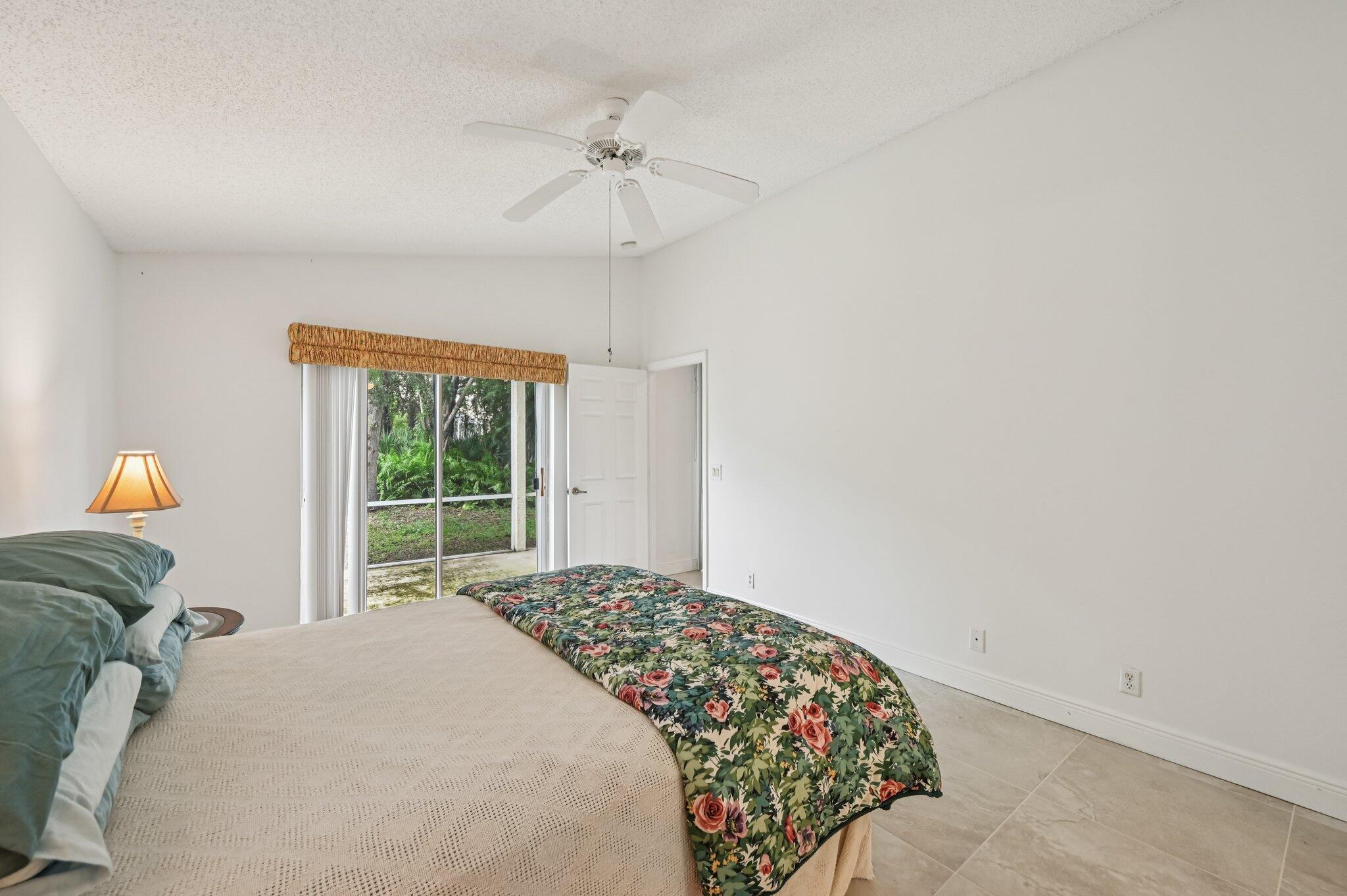 7184 Southeast Magellan Lane Stuart, FL 34997 - Photo 25 of 34 a bedroom with a bed and a chandelier
