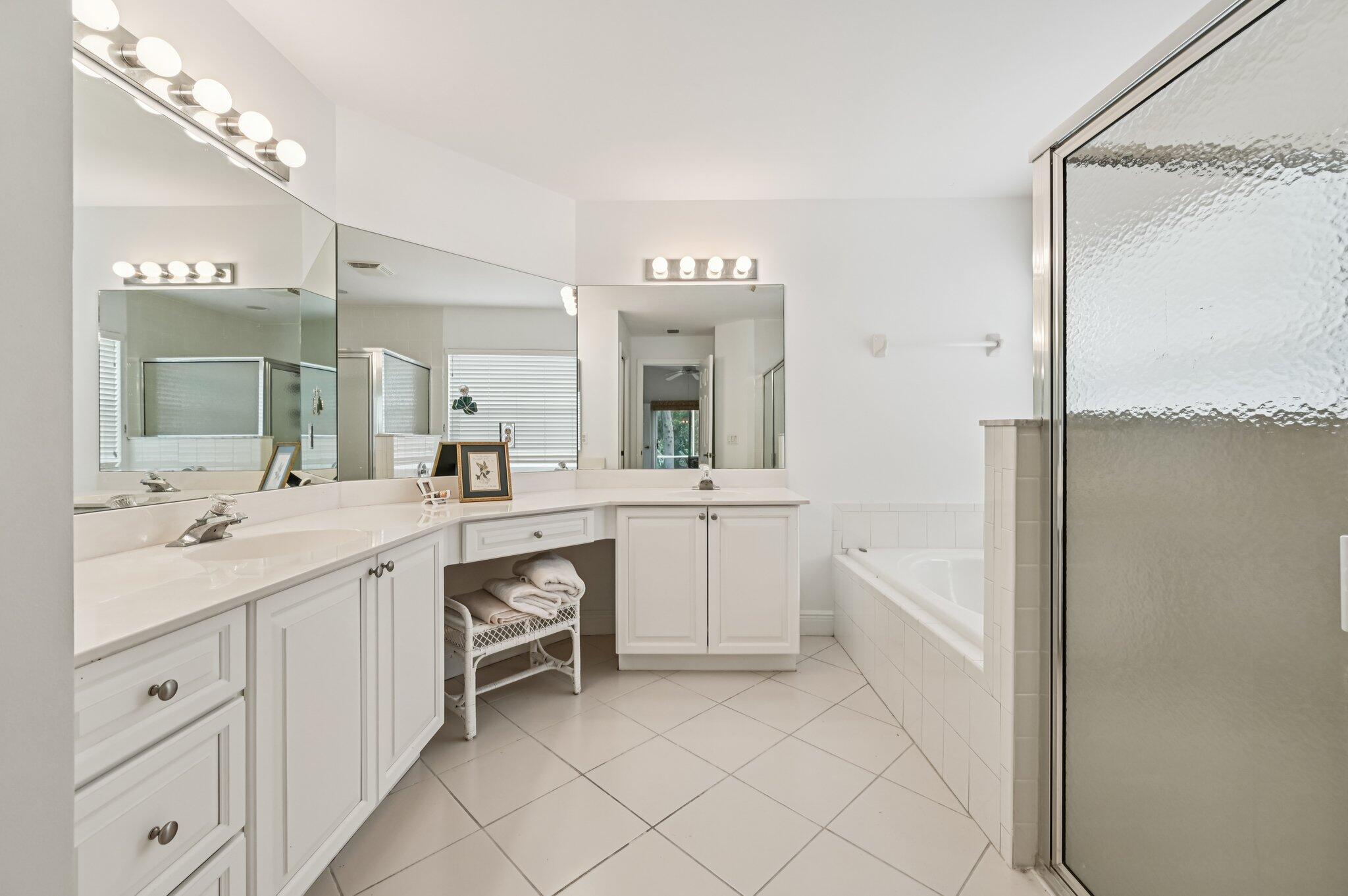 7184 Southeast Magellan Lane Stuart, FL 34997 - Photo 27 of 34 a spacious bathroom with a double vanity sink a mirror and a bathtub