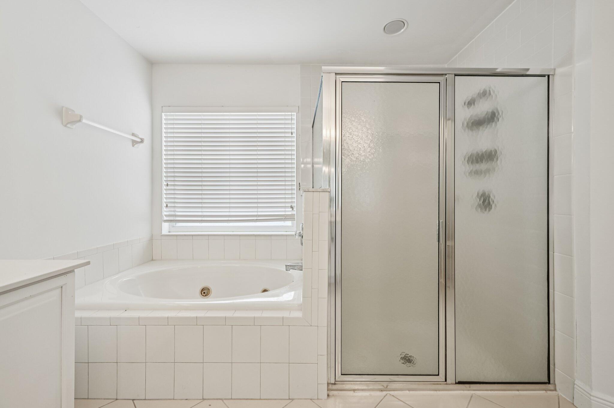 7184 Southeast Magellan Lane Stuart, FL 34997 - Photo 28 of 34 a bathroom with a bathtub and a shower