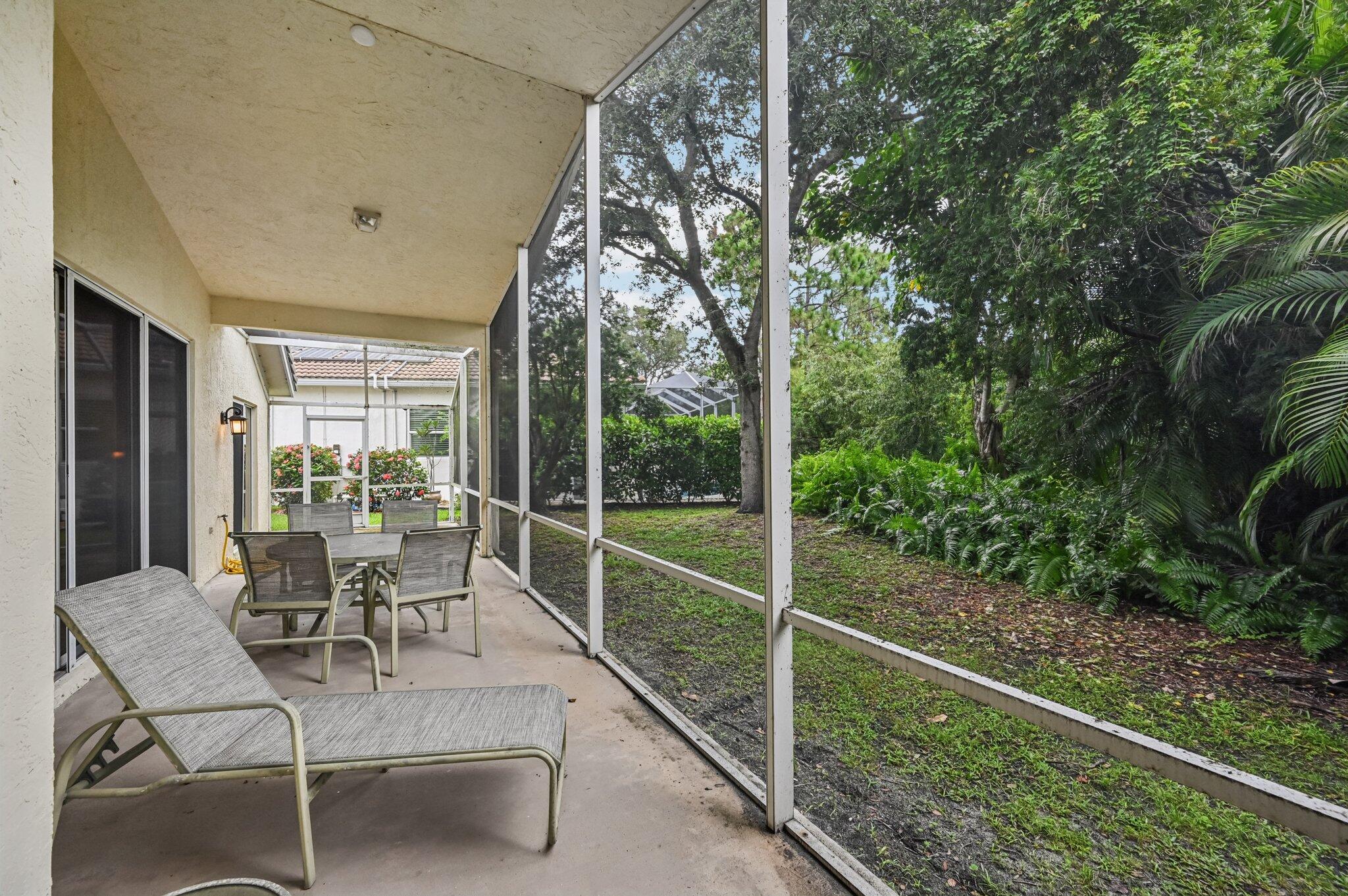 7184 Southeast Magellan Lane Stuart, FL 34997 - Photo 29 of 34 a view of a patio with table and chairs and a large tree