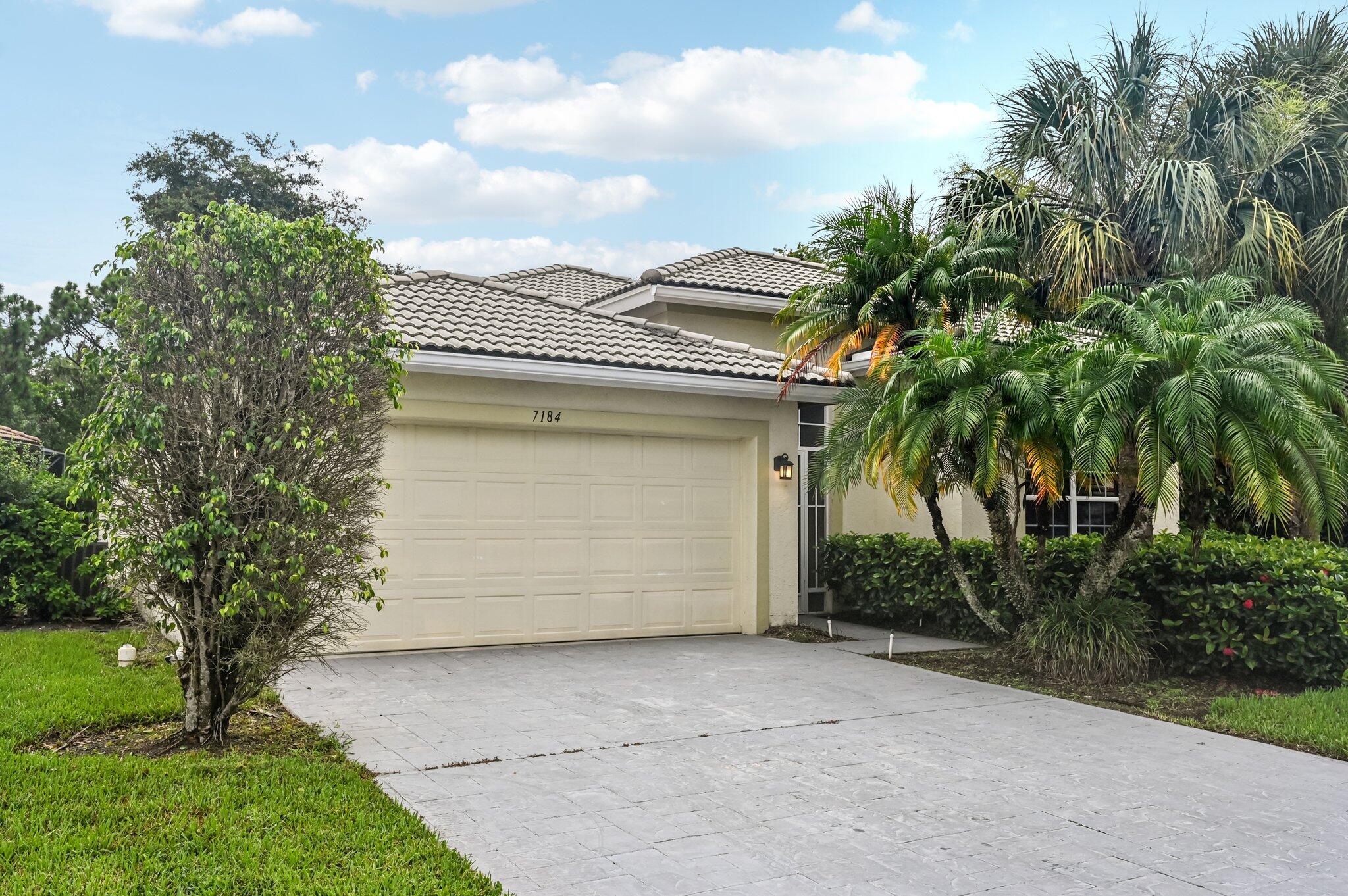 7184 Southeast Magellan Lane Stuart, FL 34997 - Photo 3 of 34 a front view of a house with a garage