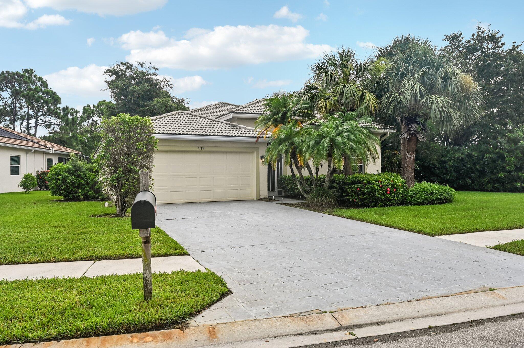 7184 Southeast Magellan Lane Stuart, FL 34997 - Photo 4 of 34 a front view of a house with garden