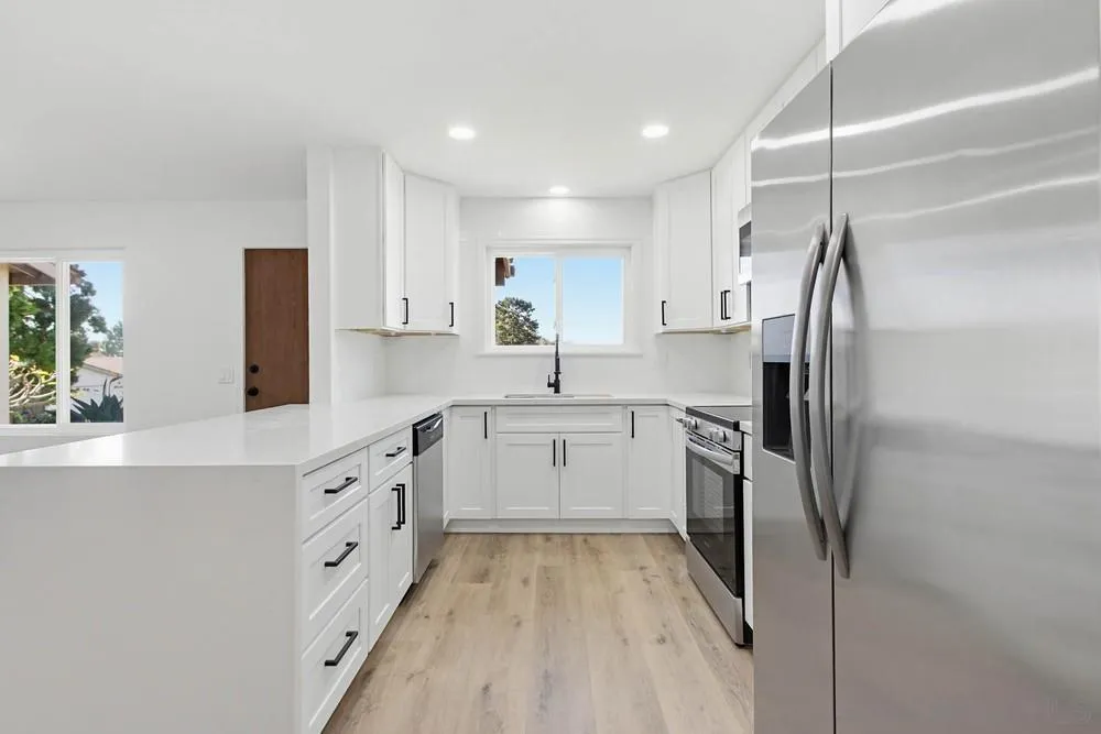 4379 Albatross Way Oceanside, CA 92057 - Photo 14 of 44 a kitchen with white cabinets and stainless steel appliances