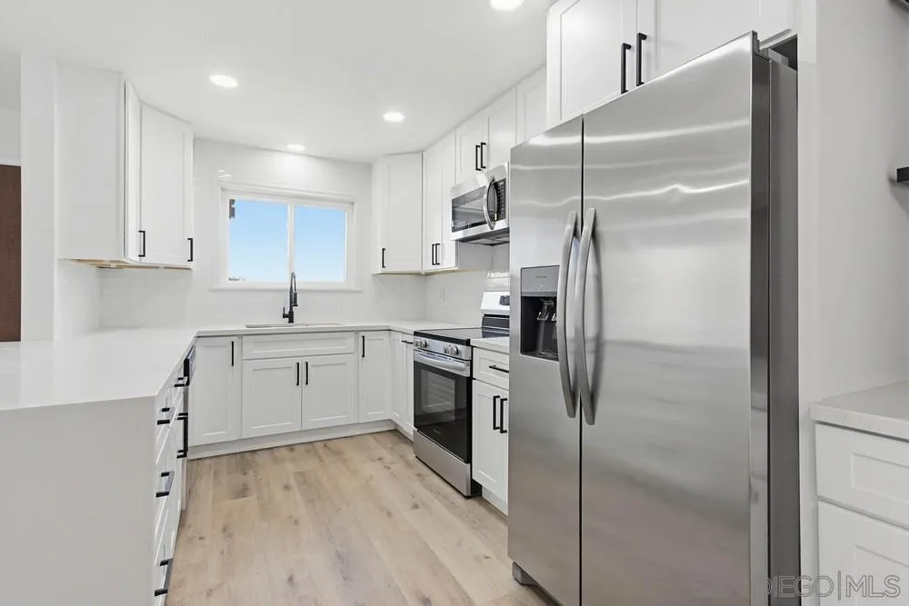 4379 Albatross Way Oceanside, CA 92057 - Photo 15 of 44 a kitchen with a refrigerator sink and cabinets