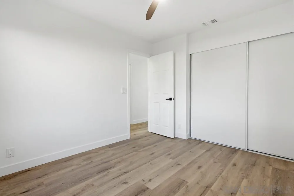 4379 Albatross Way Oceanside, CA 92057 - Photo 27 of 44 an empty room with wooden floor and windows