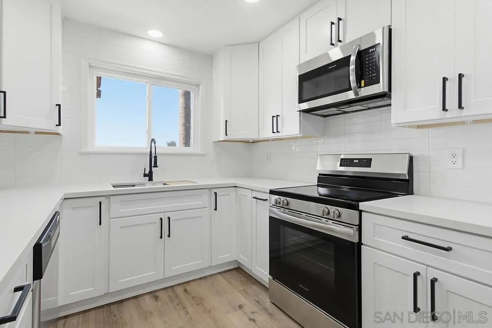 4379 Albatross Way Oceanside, CA 92057 - Photo 5 of 44 a kitchen with stainless steel appliances granite countertop grey cabinets a stove a sink and dishwasher