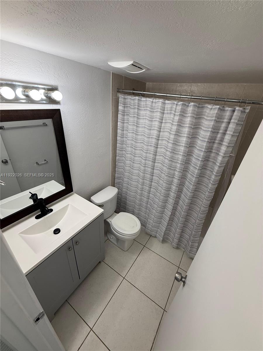 17530 Northwest 68th Avenue, Unit C3010 Hialeah, FL 33015 - Photo 4 of 7 a bathroom with a sink mirror vanity and toilet