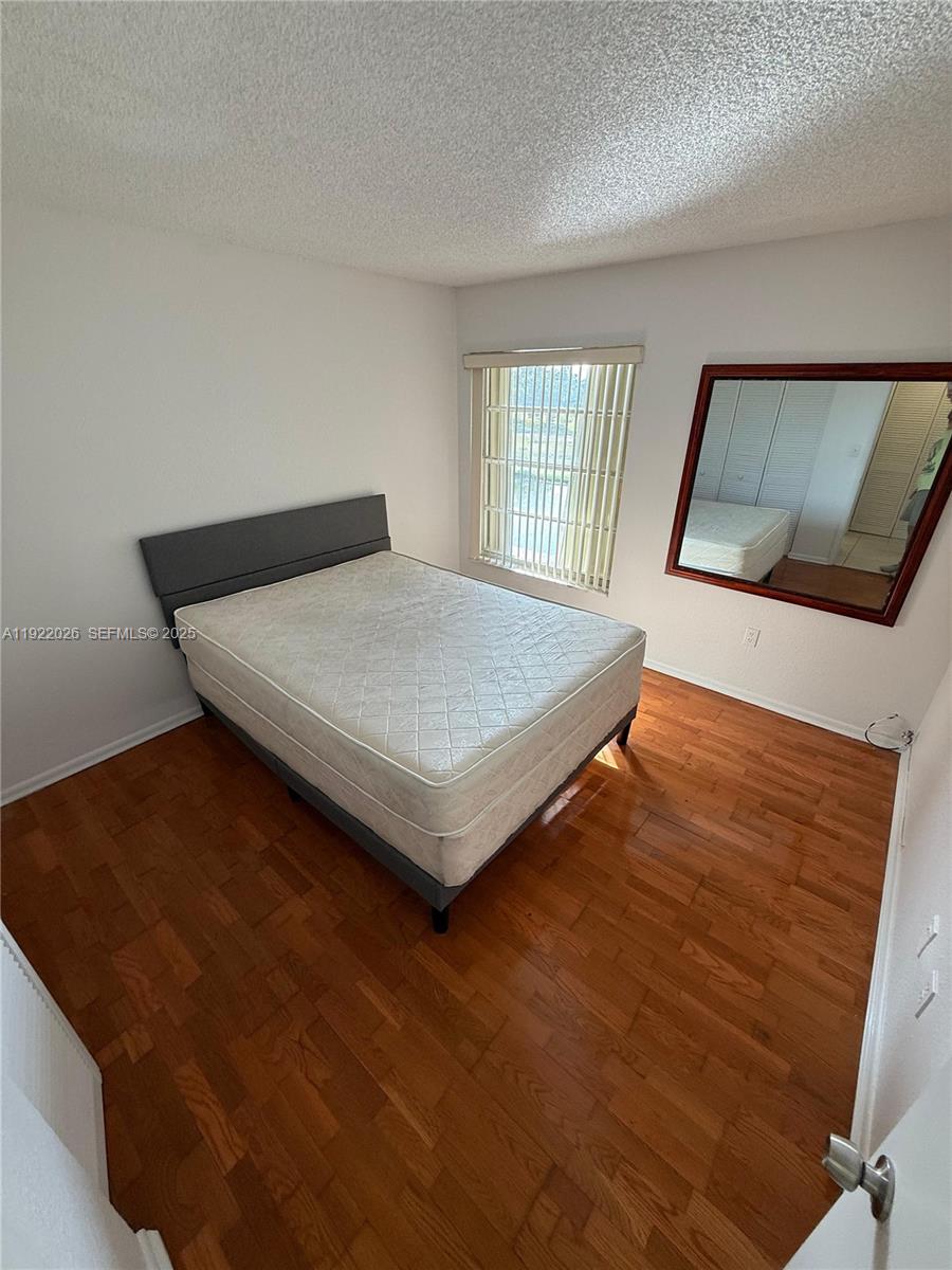 17530 Northwest 68th Avenue, Unit C3010 Hialeah, FL 33015 - Photo 5 of 7 a bed sitting in a bedroom next to a window