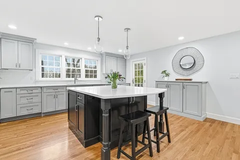 a kitchen with stainless steel appliances a dining table chairs stove and cabinets